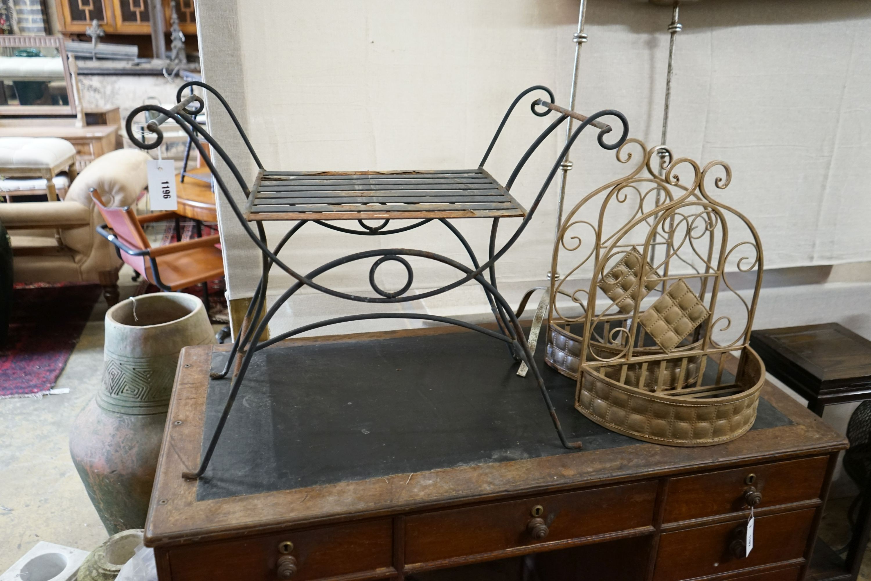 A wrought iron X framed stool, a pair of hanging planters and two large candle holders